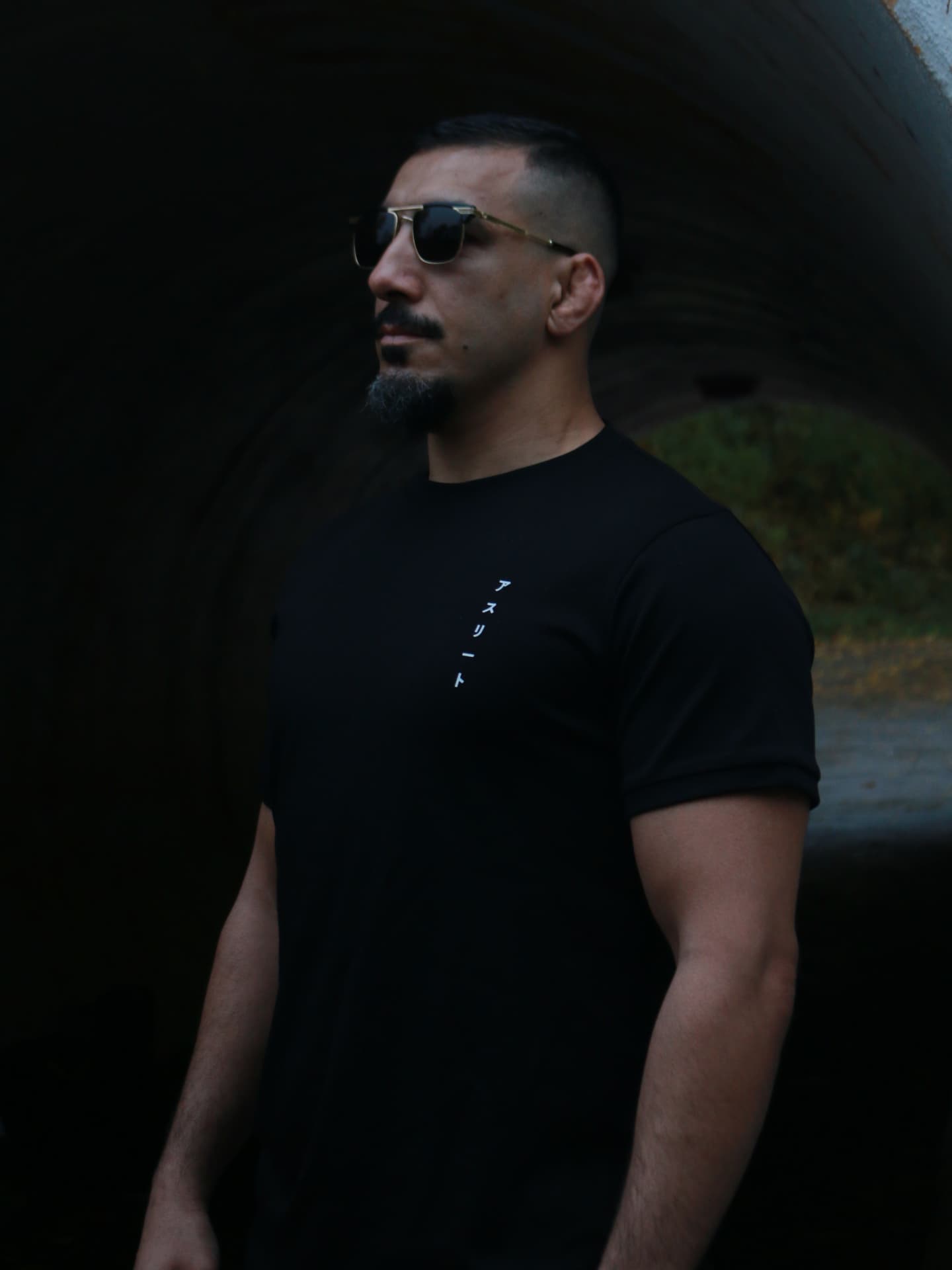 Man in a black Asurito tee with vertical katakana at the chest